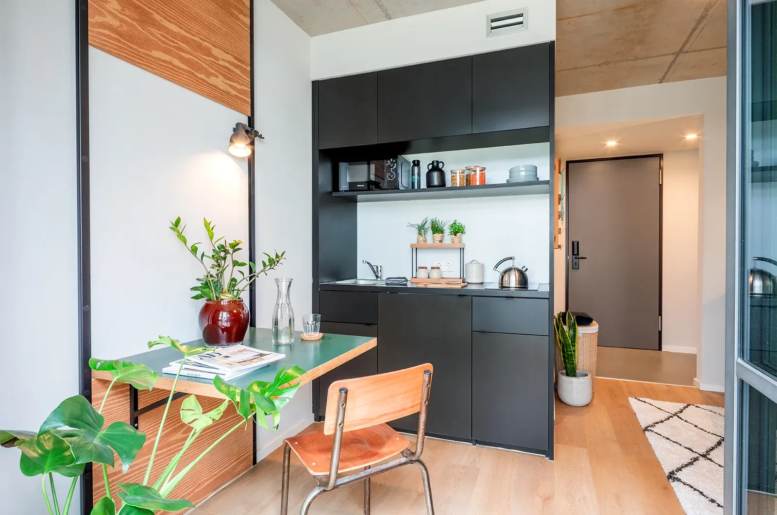 Styled kitchen and dining area with fold-out table in a Classic Patio Room at Neon Wood Berlin Frankfurter Tor showing decorated space and personalization example