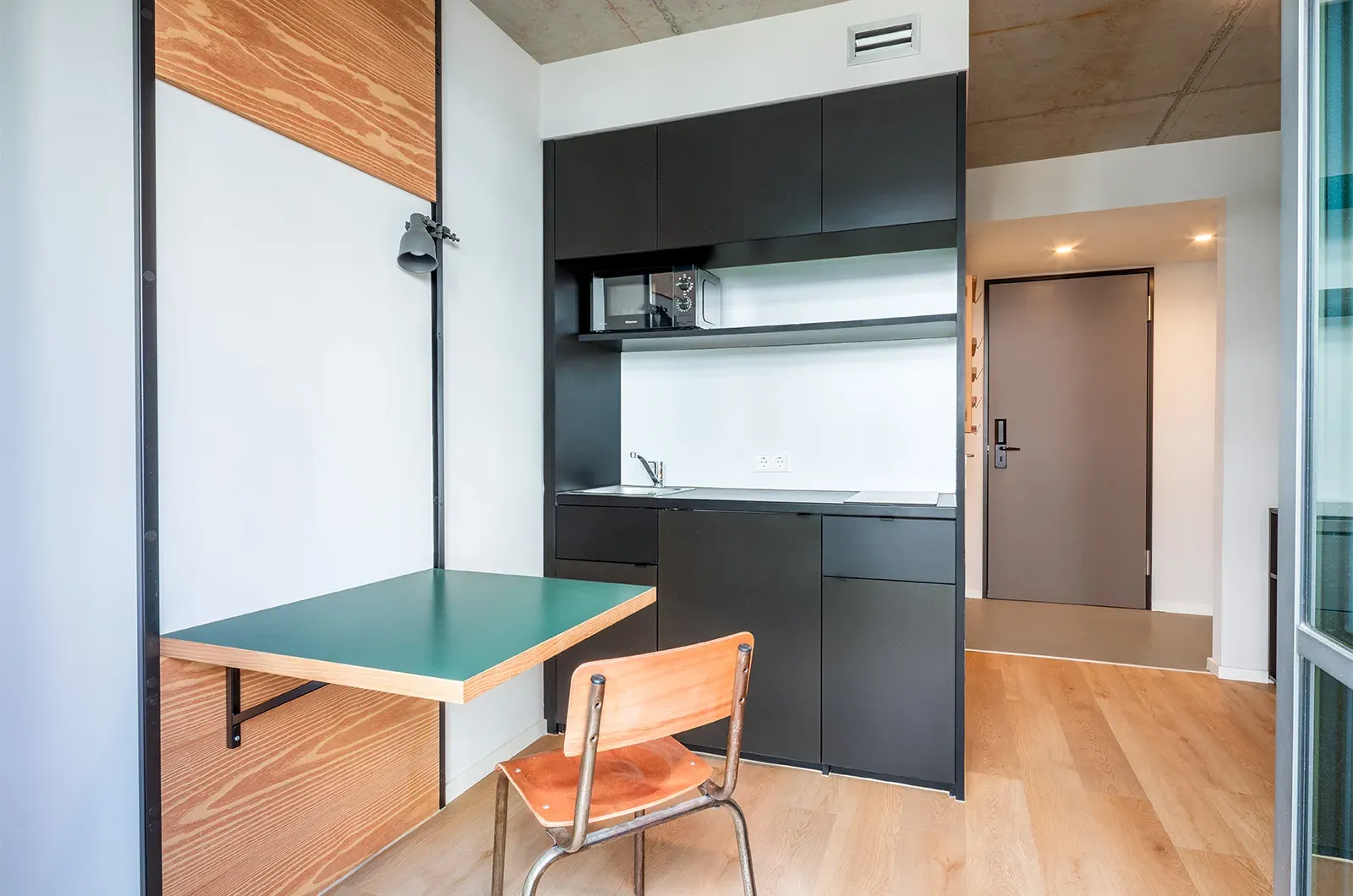 Undecorated kitchen and dining area with fold-out table in a Classic Patio Room at Neon Wood Berlin Frankfurter Tor showing furnished baseline without styling accents