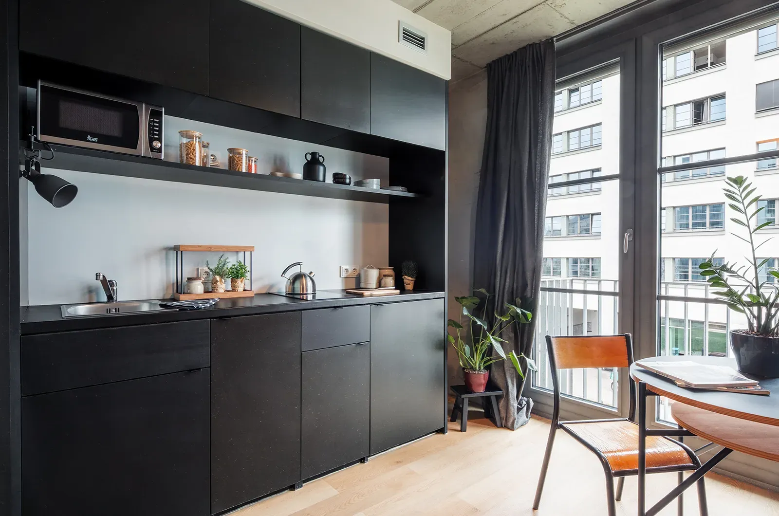 Styled close-up of the kitchen in a Deluxe Balcony Room at Neon Wood Berlin Frankfurter Tor showing decorated workspace and personalization example