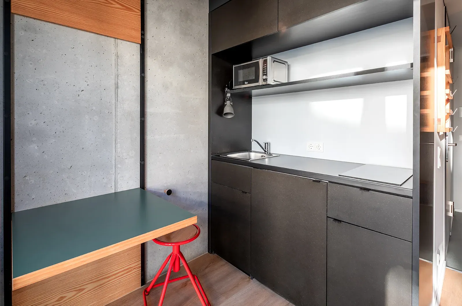 Undecorated kitchenette and foldable table in a Classic Room at Neon Wood Berlin Mitte-Wedding showing furnished baseline without styling accents