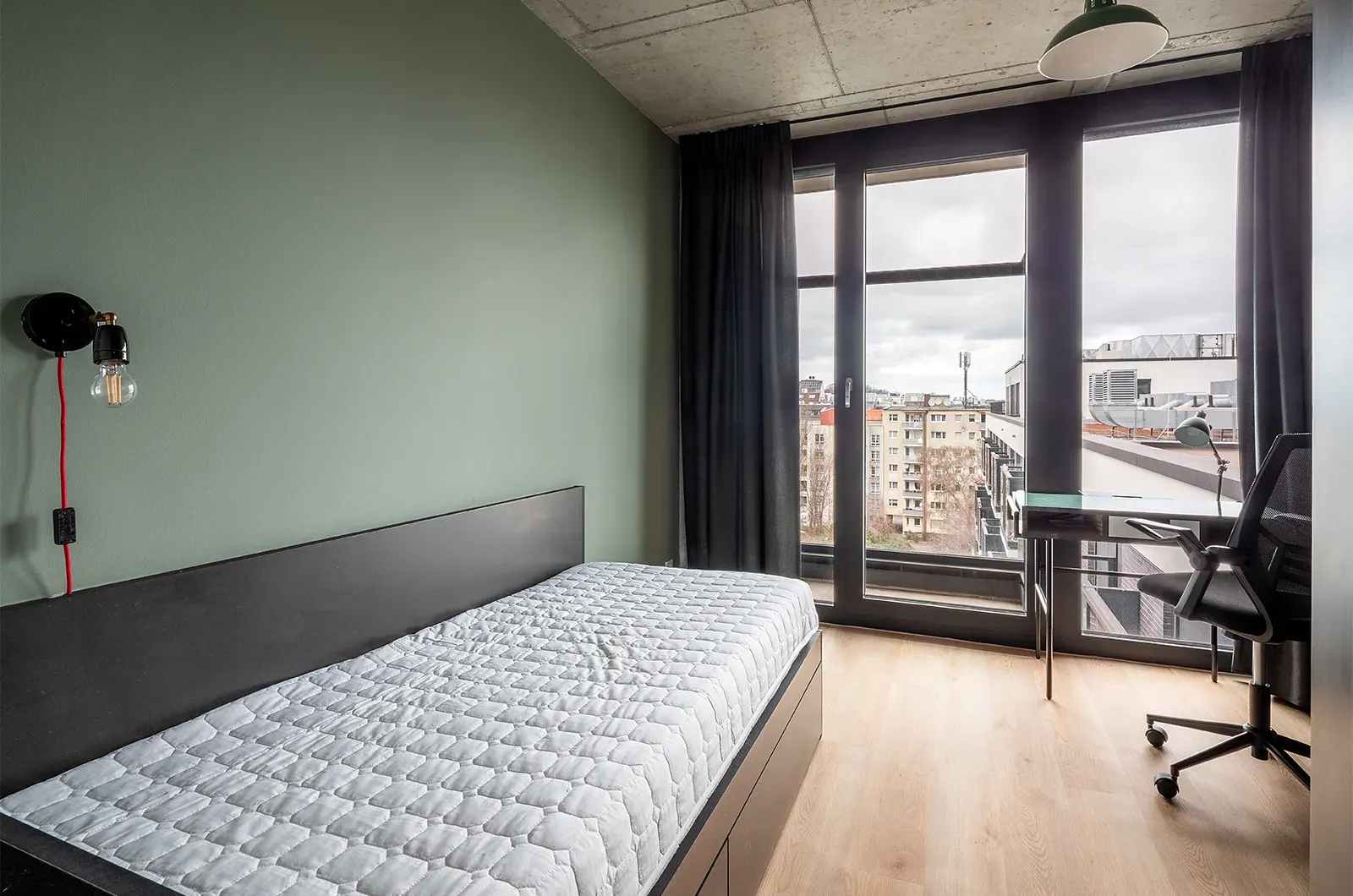 Undecorated bed area with view of the balcony and outside space in a Classic Balcony Room at Neon Wood Berlin Mitte-Wedding showing furnished baseline without styling accents