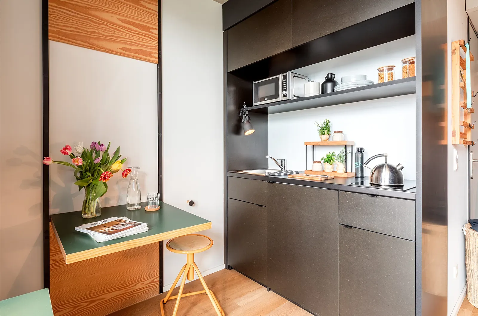 Styled kitchenette and foldable table in a Classic Balcony Room at Neon Wood Berlin Mitte-Wedding showing decorated space and personalization example