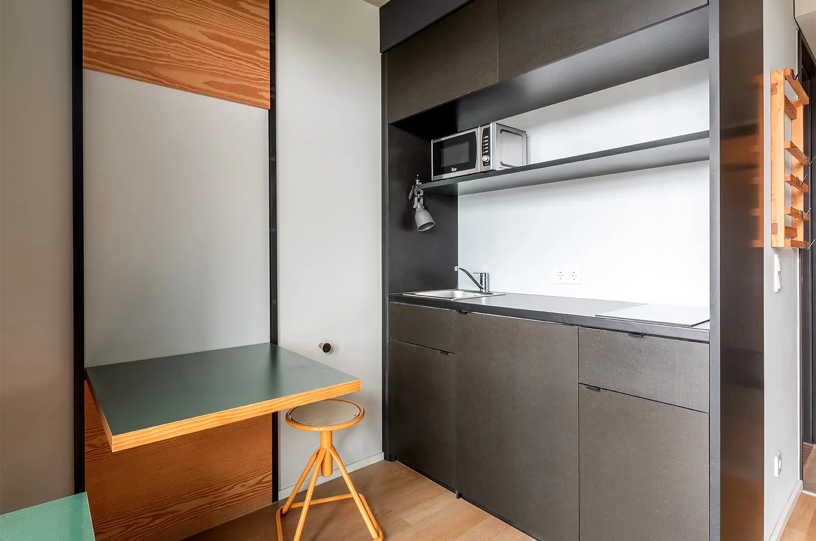 Undecorated kitchenette and foldable table in a Classic Balcony Room at Neon Wood Berlin Mitte-Wedding showing furnished baseline without styling accents