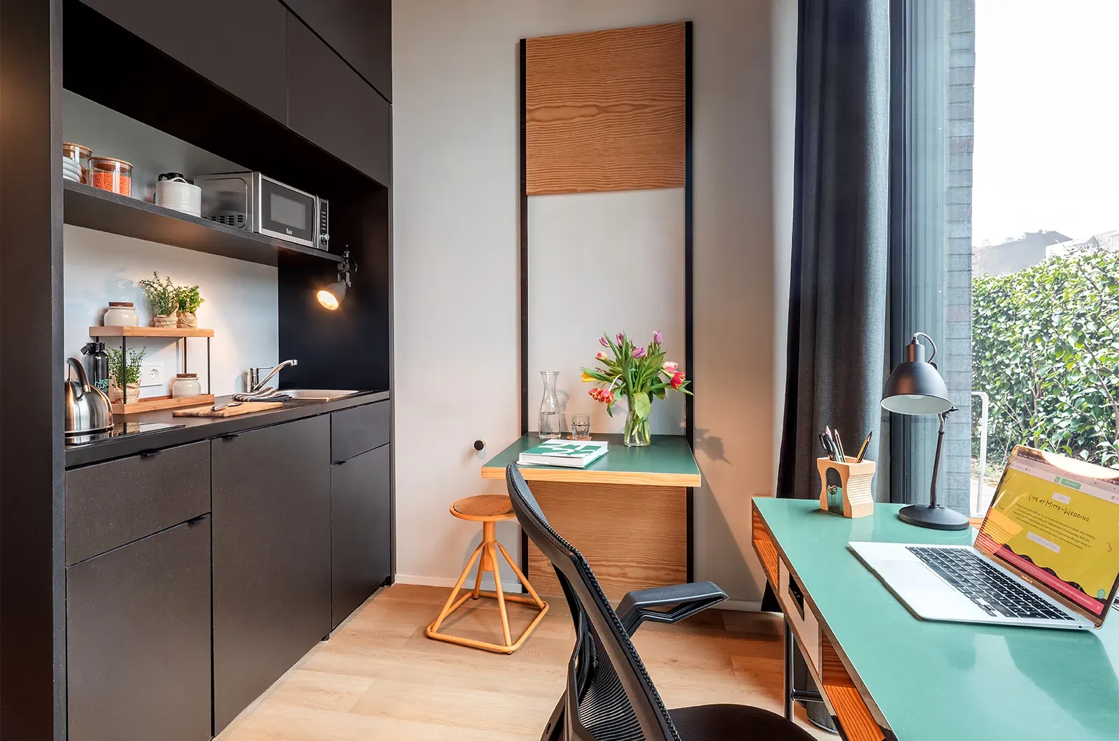 Styled desk, foldable table and kitchenette in a Classic Patio Room at Neon Wood Berlin Mitte-Wedding showing decorated space and personalization example