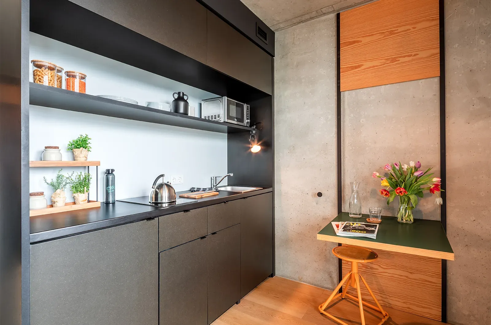 Styled kitchenette and foldable table in a Deluxe Room at Neon Wood Berlin Mitte-Wedding showing decorated space and personalization example