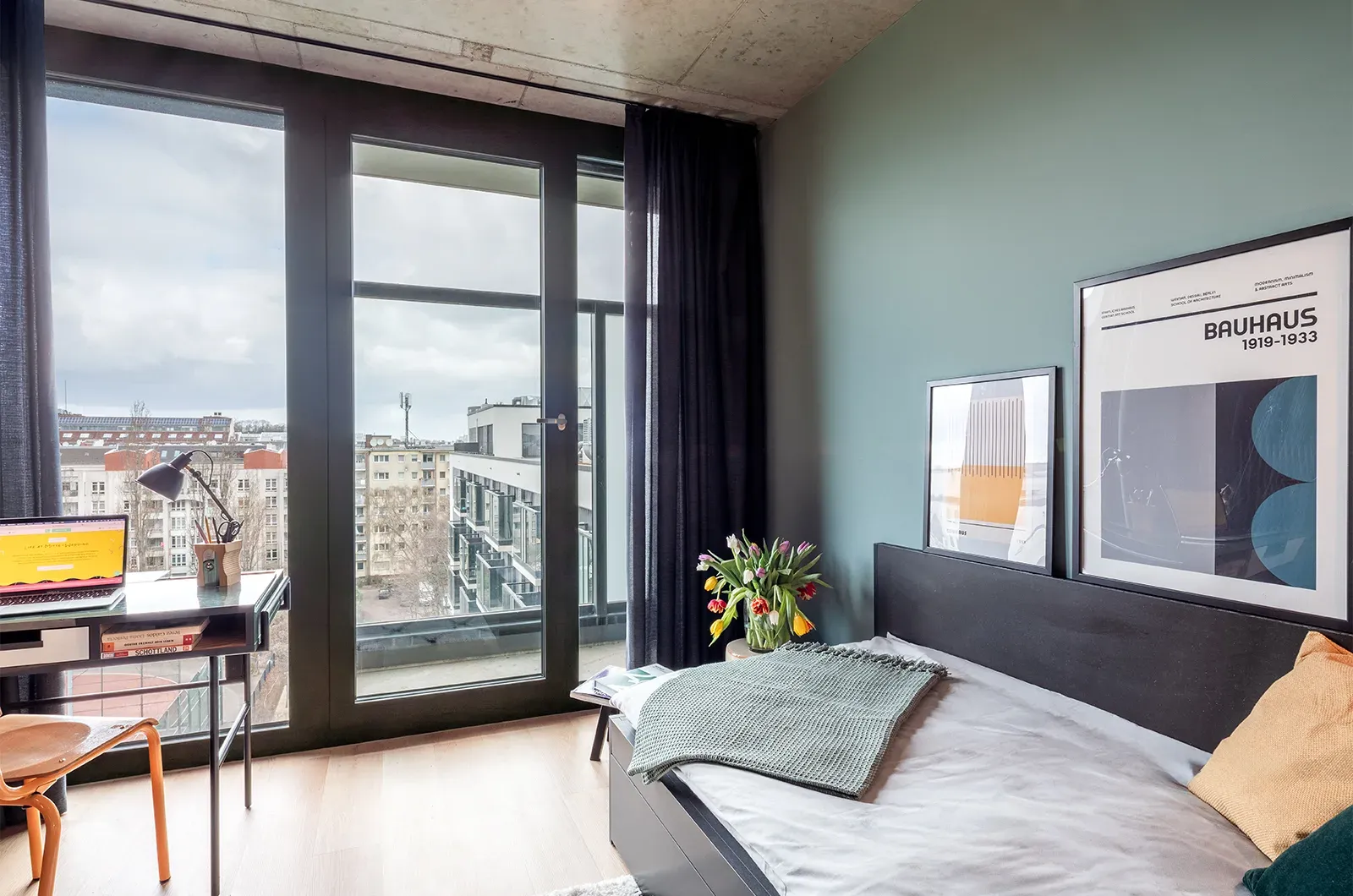 Styled bed area with view of the balcony and outside space in a Deluxe Balcony Room at Neon Wood Berlin Mitte-Wedding showing decorated sleeping space and personalization example