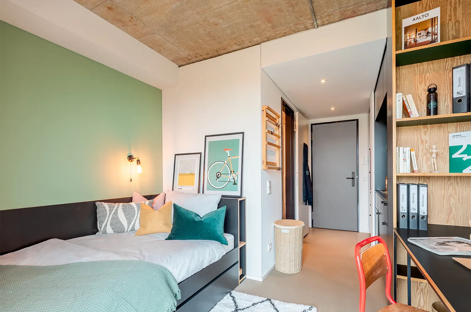 Styled bed and entrance area in a room at Neon Wood Frankfurt Riedberg showing decorated space and personalization example