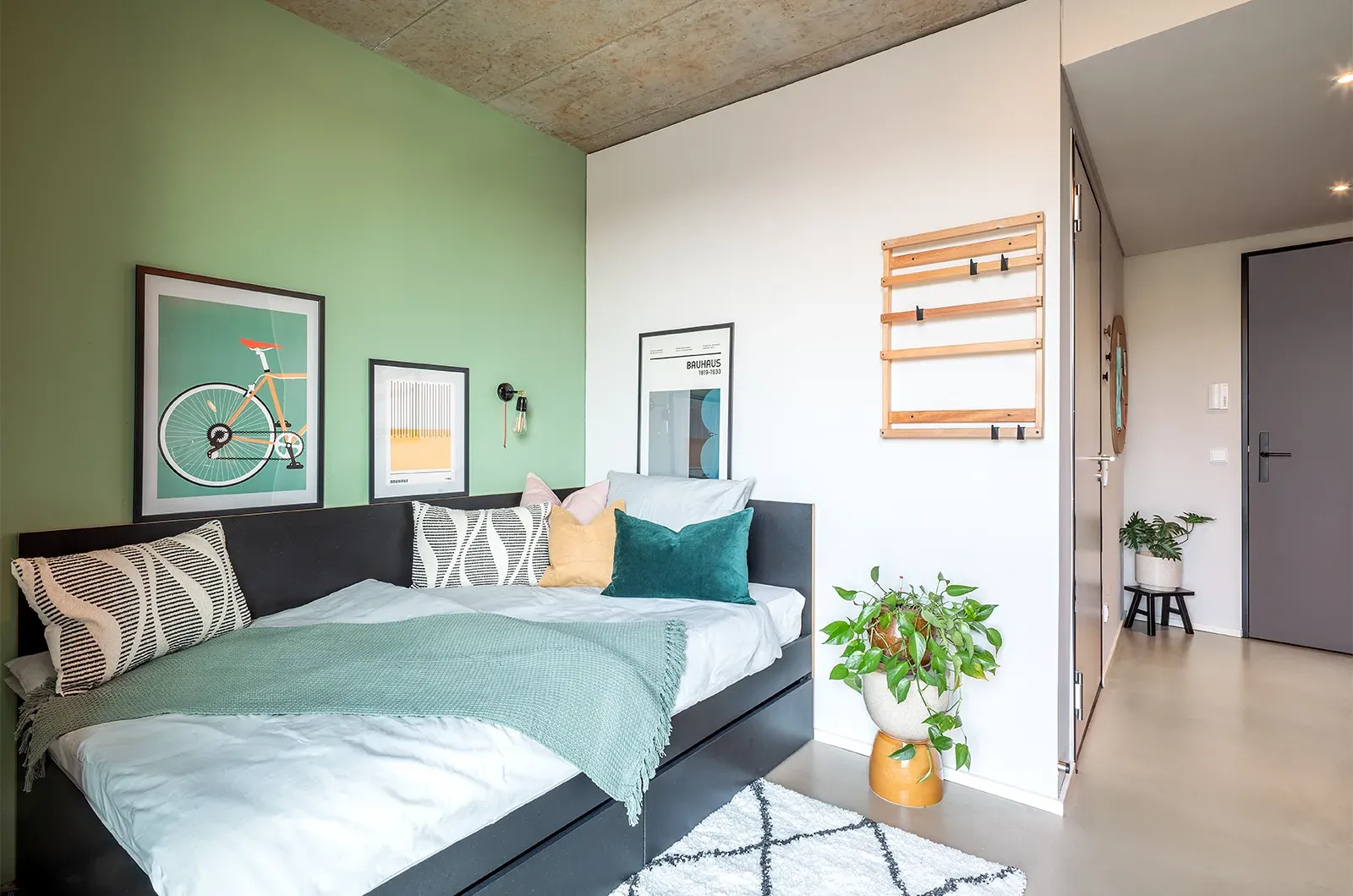 Styled bed area in a Classic Deluxe Room at Neon Wood Frankfurt Riedberg showing decorated sleeping space and personalization example