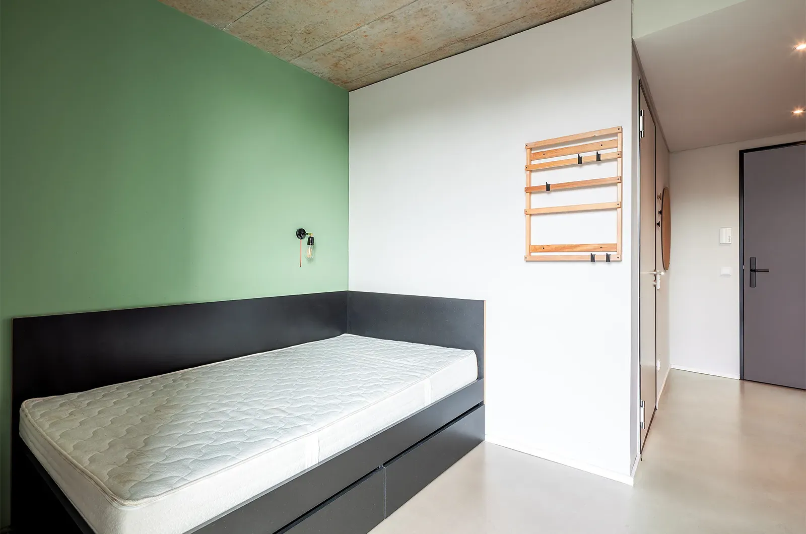 Undecorated bed area in a Classic Deluxe Room at Neon Wood Frankfurt Riedberg showing furnished baseline without styling accents