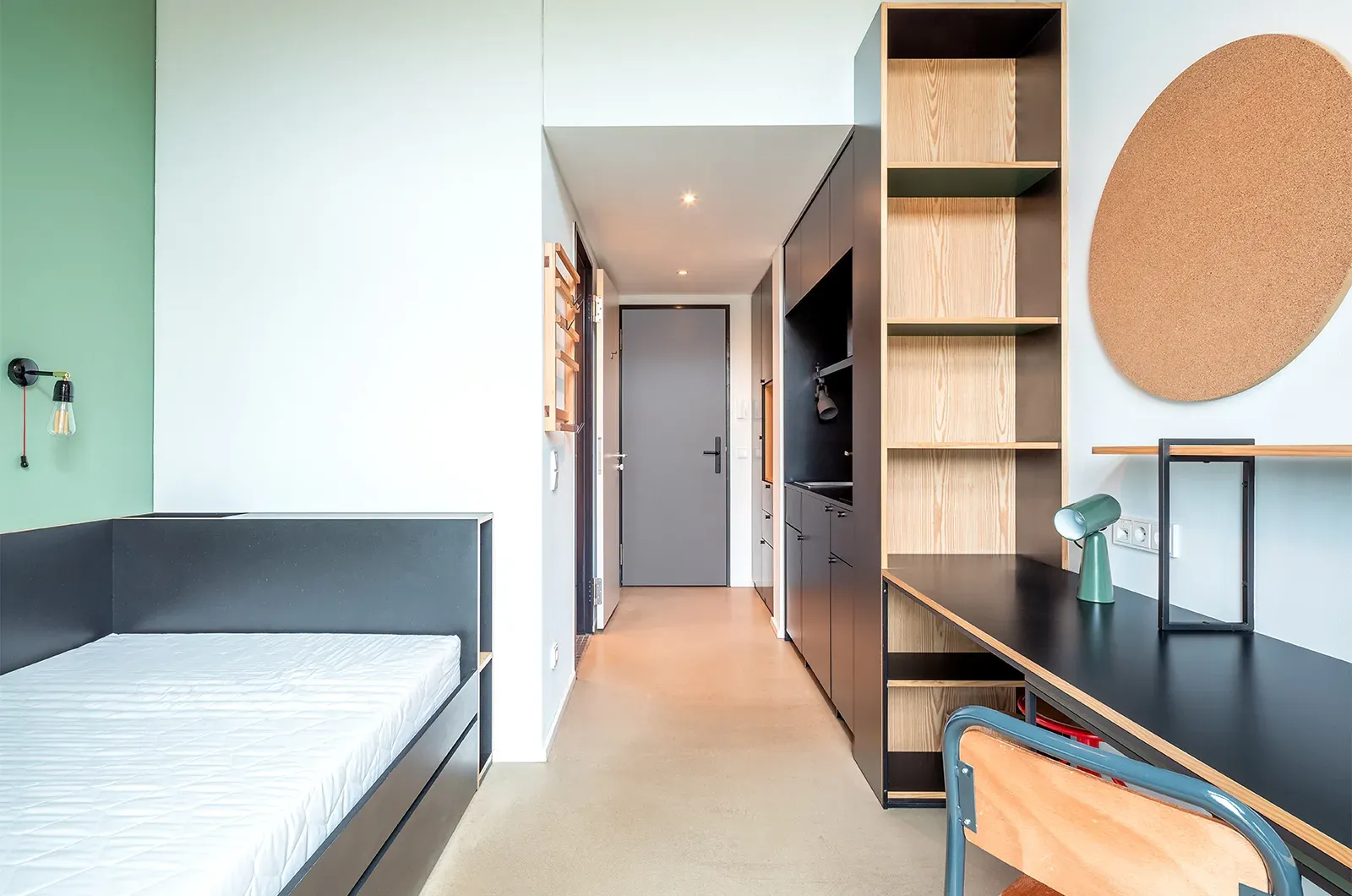Undecorated bed area, desk, storage and entrance in a Patio Room at Neon Wood Frankfurt Riedberg showing furnished baseline without styling accents