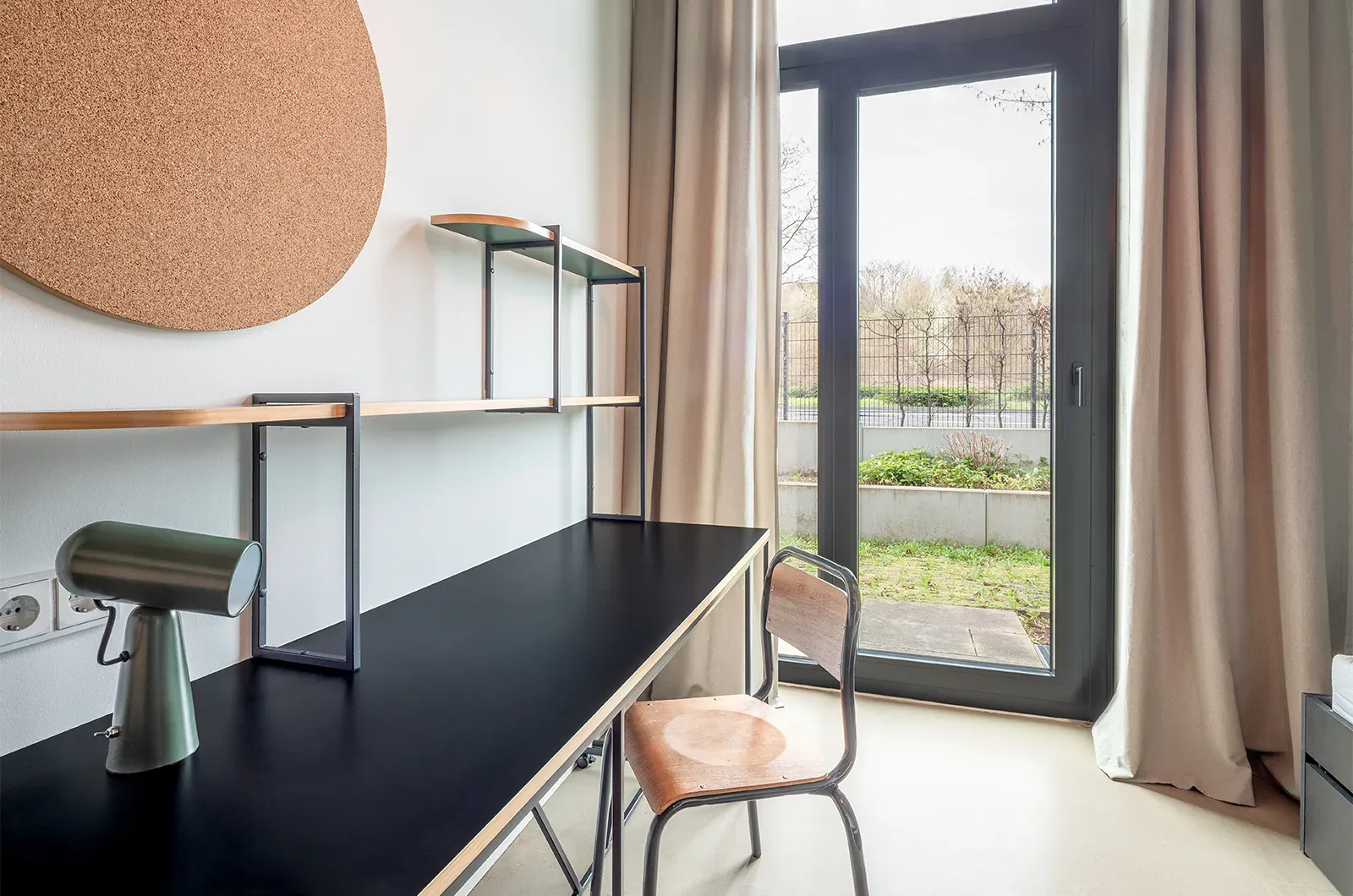 Undecorated desk and patio access in a Patio Room at Neon Wood Frankfurt Riedberg showing furnished baseline without styling accents
