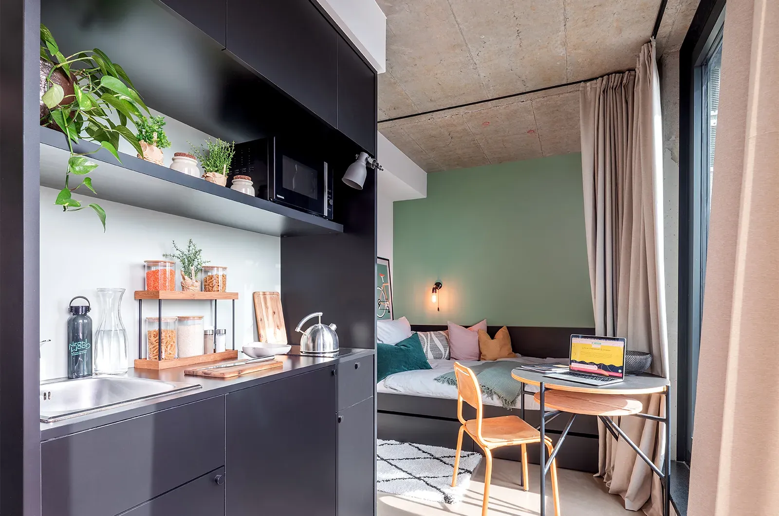 Styled kitchenette, dining and bed area in a Penthouse Balcony Room at Neon Wood Frankfurt Riedberg showing decorated space and personalization example